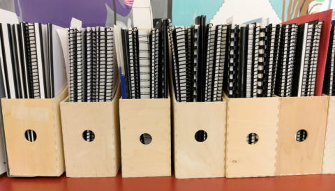 Spiral-bound senior theses organized by year, held in document organizers.